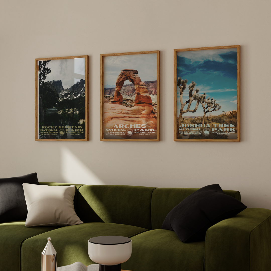 a living room with a green couch and two posters on the wall