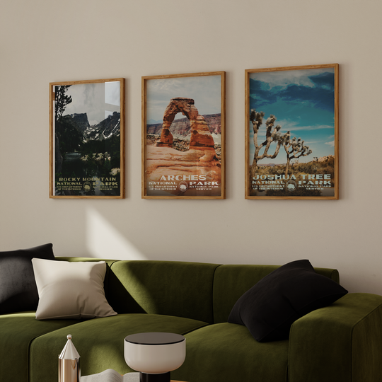 a living room with a green couch and two posters on the wall