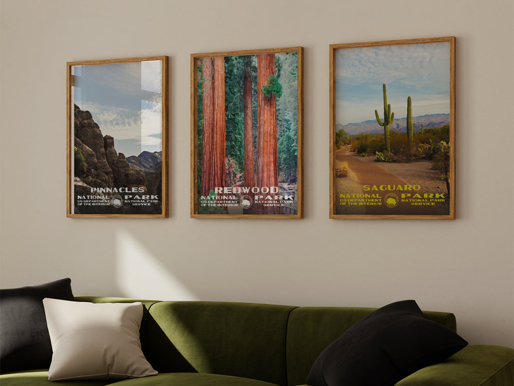 a living room with a green couch and three posters on the wall