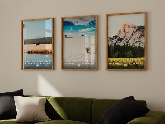 a living room with a green couch and three pictures on the wall