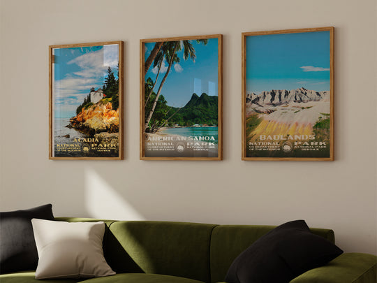 a living room with a green couch and three posters on the wall