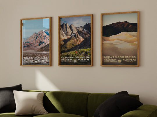 a living room with a green couch and three posters on the wall