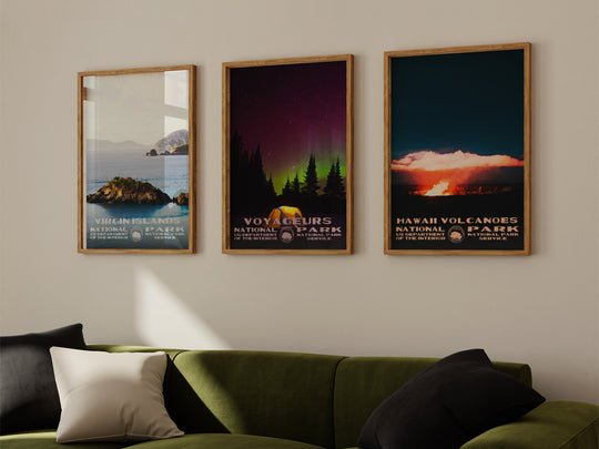 a living room with a green couch and three posters on the wall